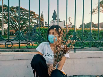 Portrait of young woman sitting outdoors