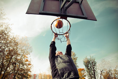 A man shoots the ball into a basketball hoop
