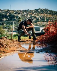 Side view of man with reflection in water