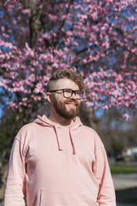 Portrait of young man standing against trees