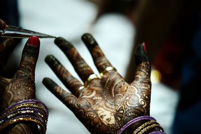 Cropped hands with henna tattoo