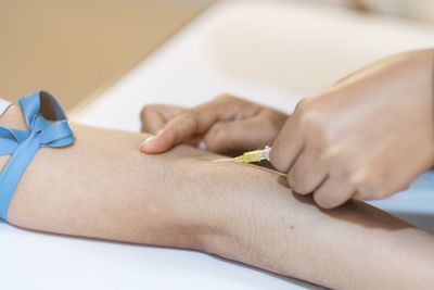 Midsection of woman holding paper with text on table