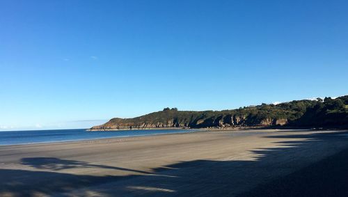 Scenic view of beach against clear blue sky