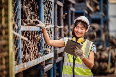 Confident female engineer looking at worksheet on tablet