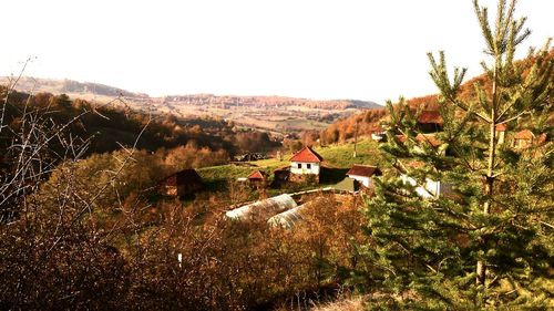 Houses on landscape against clear sky