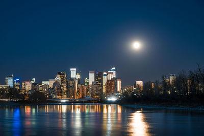 Illuminated buildings against sky at night