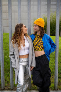 Portrait of young woman standing against wall