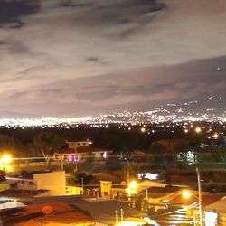 Illuminated cityscape against sky at night