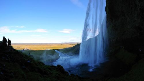 Scenic view of waterfall against sky