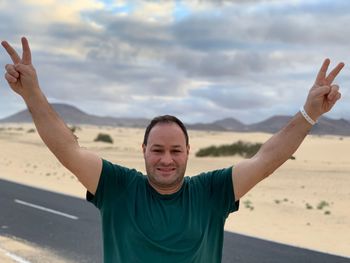 Portrait of man standing at beach against sky