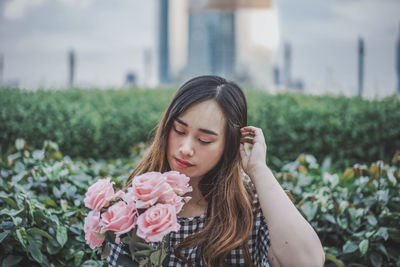 Portrait of beautiful woman with red flower