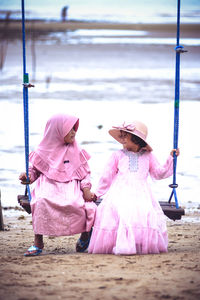 Cute girls wearing dress sitting on swing