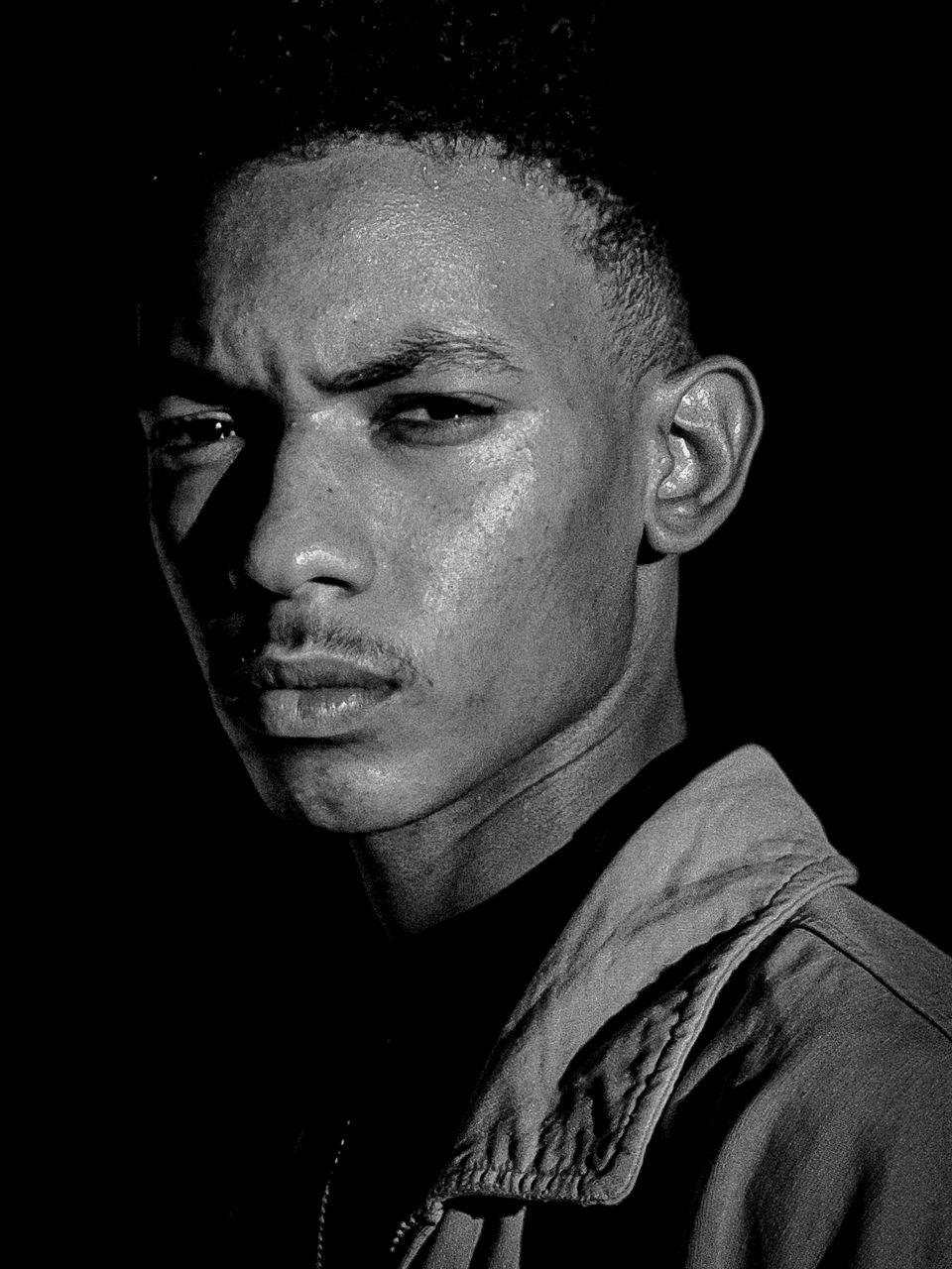 portrait, black and white, one person, headshot, black background, studio shot, adult, monochrome photography, monochrome, looking at camera, black, indoors, serious, close-up, men, young adult, human face, lifestyles, looking, dark, darkness, person, front view