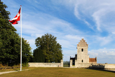 View of flag on building against cloudy sky