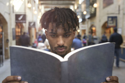 Portrait of young man sitting on book