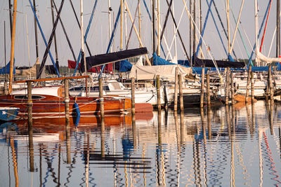 Moored sailboats in marina with reflections in the water