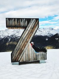 Built structure on snow covered mountain against sky