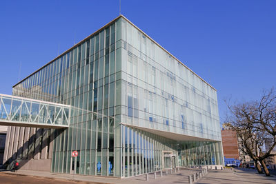 Low angle view of modern building against clear blue sky