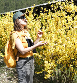 Portrait of young woman standing against plants