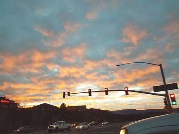 Cars on road against sky during sunset