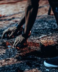 Low section of man collecting stones on footpath