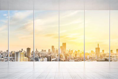 Cityscape seen through glass window during sunset