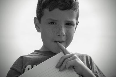 Portrait of boy holding book at home