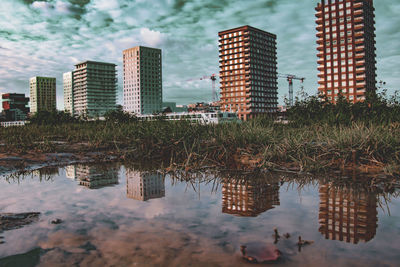 Reflection of buildings on lake against sky