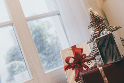 Gift boxes near christmas tree inside home. box with holiday ribbon with bows. festive atmosphere