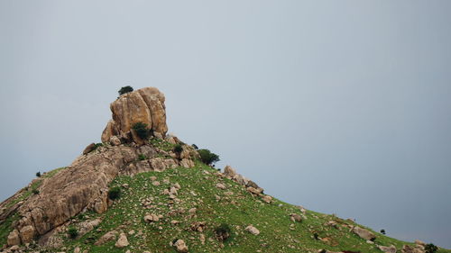 Low angle view of rock on mountain against clear sky