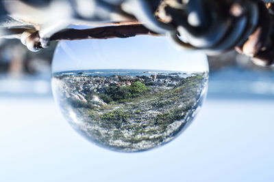 Close-up of glass of water against sky