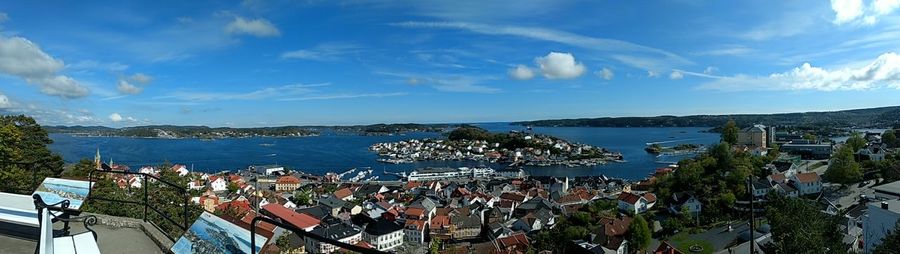 Panoramic view of sea by town against sky