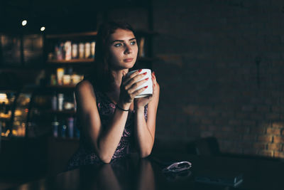 Portrait of a young woman drinking coffee