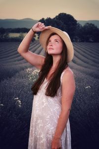 Portrait of beautiful young woman standing in hat