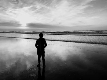 Rear view of man standing on beach