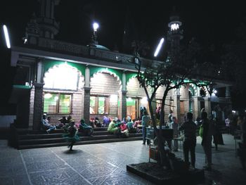 People walking in illuminated building at night