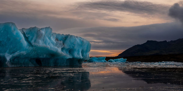 View of iceberg in sea during sunset