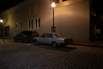 Car on street against illuminated buildings in city at night