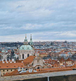 View of buildings in city against cloudy sky