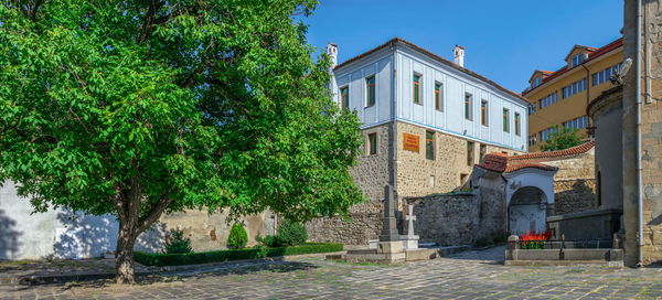 Trees by building against blue sky plovdiv, bulgaria