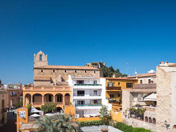 Buildings against clear blue sky in city