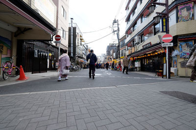 People walking on street amidst buildings