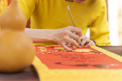 Midsection of woman writing on paper