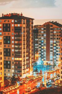 Buildings in city against sky during sunset