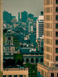 Aerial view of buildings in city against sky