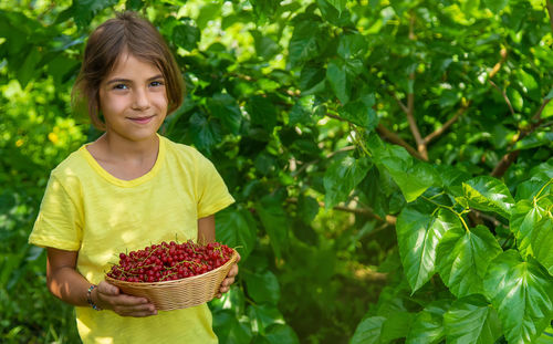 Portrait of girl holding berries in basket