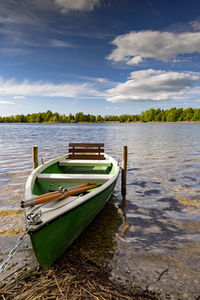 Boat moored on shore against sky