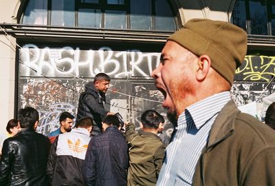 Men with text on wall in city