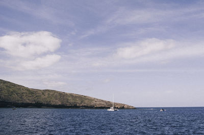 Sailboat sailing on sea against sky