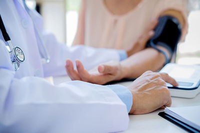 Midsection of doctor examining patient in hospital